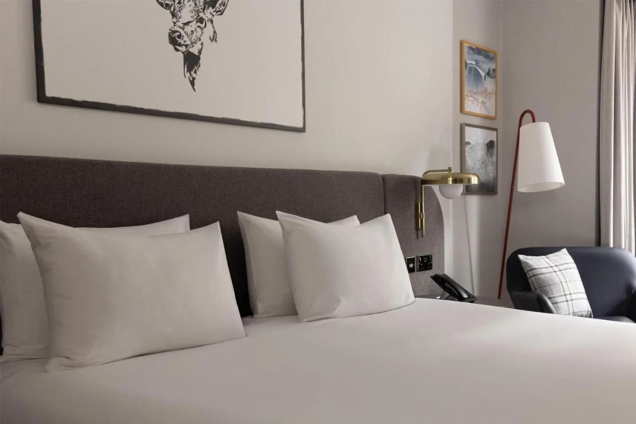 a bedroom with a bed with white pillows and a lamp at JA The Bruntsfield - Edinburgh in Edinburgh